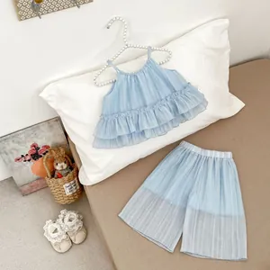 Détail d'un ensemble d'été bleu clair pour fillette avec haut à volants et short plissé