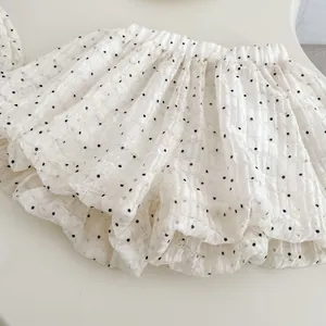 Detail of baby girl's polka dot puffy skirt showing elastic waist and textured fabric