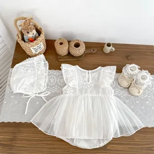 Flat lay of white baby girl floral embroidery dress with matching lace hat and soft shoes