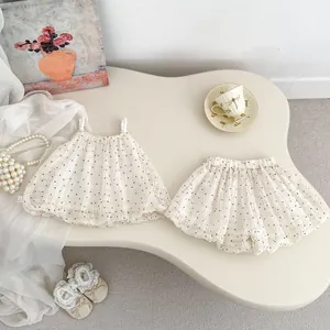 Detail of baby polka dot outfit with pearl straps and washing label on beige fabric