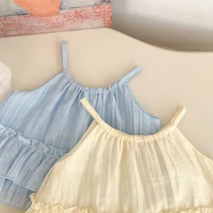Détail de hauts à volants en coton plissé bleu clair et beige pour petites filles