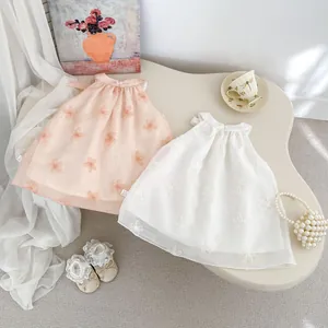 Dettaglio di tulle ricamato con applicazioni floreali 3D su abiti smanicati da bambina