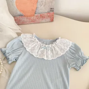 Close-up of light blue knit top featuring a white lace ruffled collar and ribbon bow