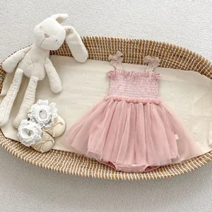 Detailed flat lay of a pink tutu romper with mesh skirt in a woven baby basket