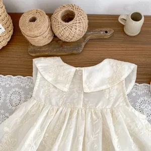 Detailed embroidery on white toddler sleeveless dress with Peter Pan collar and ruffles