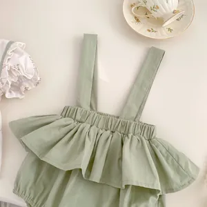 Detalle de blusa floral para bebé y pelele verde menta con cuello de volantes decorativo