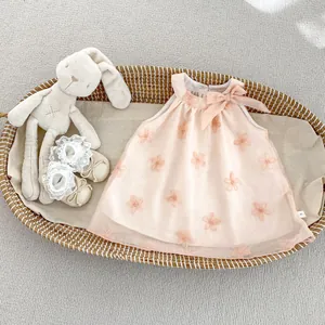 Dettaglio dell'abito rosa senza maniche per bambina con fiori 3D e fiocco decorativo