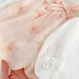Pink and white baby romper with floral embroidery and silk bow detail for girls