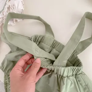 Detalle de bombacho de lino verde claro para bebé con tirantes y botones