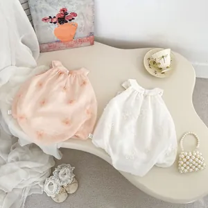 Detail of baby floral embroidery romper with 3D petals and delicate lace accessories