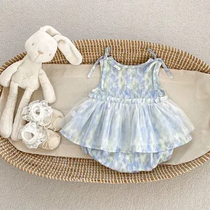 Détail d'un barboteuse bébé à fleurs avec jupon en tulle et jolis nœuds sur plateau