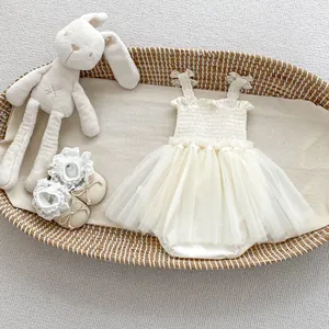Detailed view of baby girl tulle romper dress with lace straps and matching bow shoes