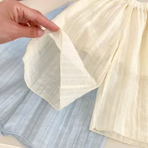 Détail du tissu rayé et respirant des shorts pour bébés en beige et bleu clair