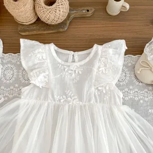 Detailed embroidery of white flowers and ruffled sleeves on a baby mesh romper dress