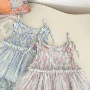 Détail d'un barboteuse sans manches en tulle pour bébé avec nœuds et motifs tie-dye