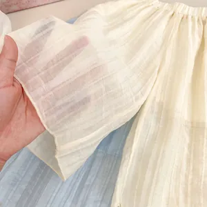 Gros plan d'un tissu texturé crème avec rayures verticales et design plissé léger