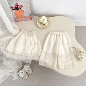 Flat lay of girl's summer cream lace vest and wide-leg pants with dot embroidery detail
