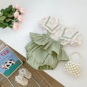 Detalle de blusa floral para bebé y pololo con volantes con encaje y decoración vintage