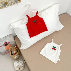 Close-up of baby ribbed cotton camisole sets with 3D cherry embroidery in red and cream