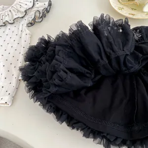 Detail von weißem Polka-Dot-Oberteil mit schwarzem, gestuftem Tüll-Rock für Mädchen
