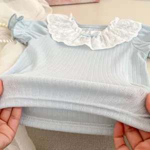Detail of baby girl light blue ribbed top featuring embroidered lace Peter Pan collar