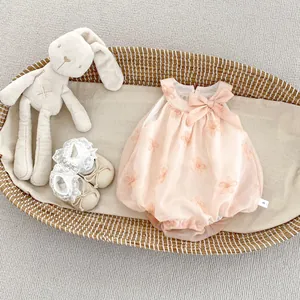 Detailed flat lay of pink infant floral embroidery romper with bow and lace baby shoes