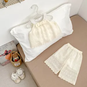 Close-up of cream lace girls' set featuring dot texture and hollow lace-trimmed edges