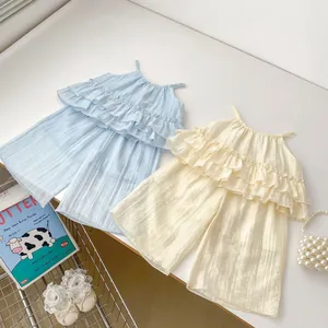 Détail de hauts à volants et pantalons larges pour filles en bleu clair et beige crème