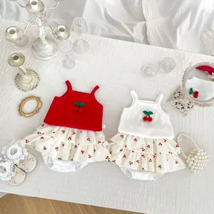 Detailed flat lay of baby cherry embroidered tank tops and tiered skirts in red and white