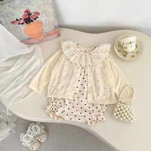 Détail du cardigan bébé à col dentelle et barboteuse à motif cœur avec accessoires