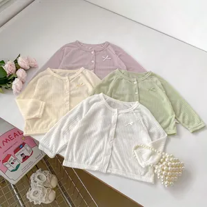 Gilets en maille pour bébé avec nœud décoratif en rose, jaune, vert et blanc, vue à plat
