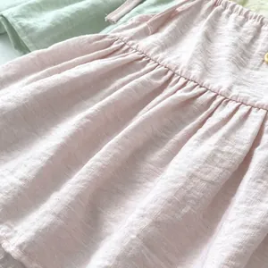 Detail der rosa Baumwoll-Leinen-Kleid mit Rüschen und runden Knöpfen aus Stoff