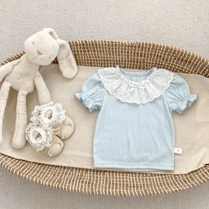Close-up of baby girl blue ribbed top with wide lace collar and ruffled sleeve details