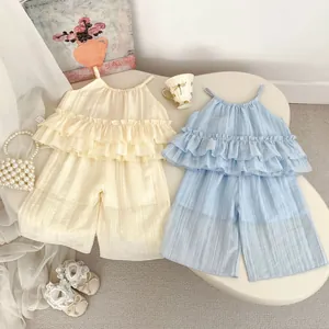 Détail de l'ensemble filles haut à volants et short large en beige et bleu clair