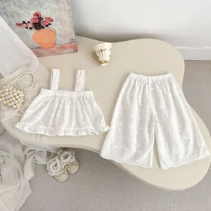 Détails d'un ensemble d'été blanc pour fille avec broderie florale et bords à volants