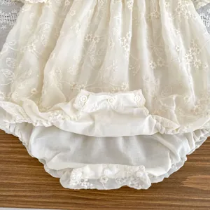 Detail of baby bodysuit with floral embroidery, mesh sleeves, and snap buttons