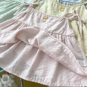 Detailaufnahme des Mädchen-Baumwolloberteils mit Holzknöpfen und Crêpe-Struktur in Rosa