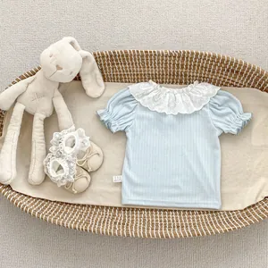 Detail of baby girl summer outfit with lace collar and ribbed light blue cotton texture