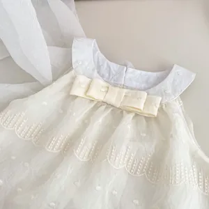 Detailed embroidery on a cream baby dress featuring a Peter Pan collar and bow