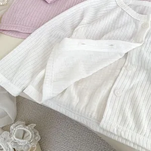 Détail du cardigan de protection solaire en coton tricoté rose clair à texture côtelée