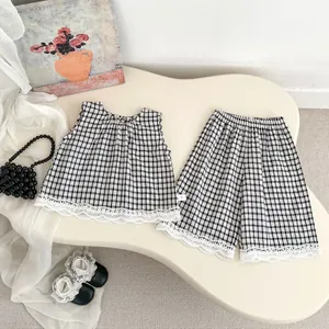 Detailed flat lay of toddler plaid set with lace trim and embroidered sleeveless top