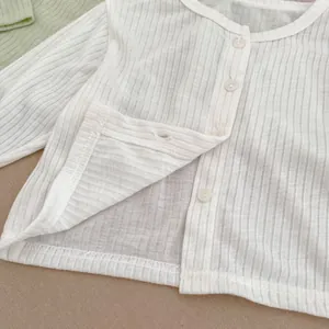 Detailansicht der weißen Rippstrick-Strickjacke mit Rundhals und Knopfleiste