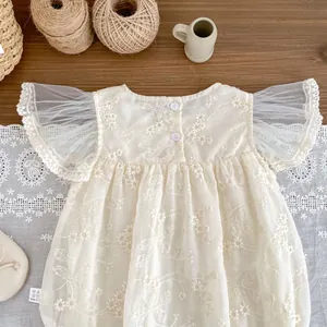 Detail of baby girl bodysuit featuring floral embroidery and lace mesh flutter sleeves