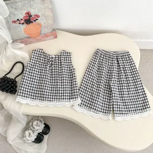 Flat lay of plaid sleeveless top and wide-leg pants set with delicate lace trim detailing