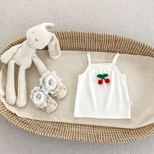 Close-up of baby rib cotton top with cherry patch and lace trim shoes in a basket