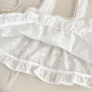 Détail du haut blanc en coton pour filles avec broderie en dentelle et bords volantés