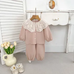 Detail des weißen Spitzenkragens mit Blumenstickerei am rosa Baumwollset für Mädchen
