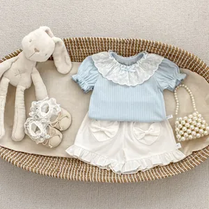Detail of baby girl summer outfit featuring white lace collar and heart-shaped back pockets