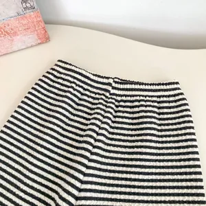 Dettaglio dei pantaloni larghi a righe con tessuto seersucker e vita elastica
