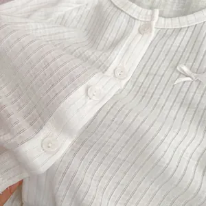 Détail de la maille côtelée, petits boutons et nœud sur la chemise de protection solaire